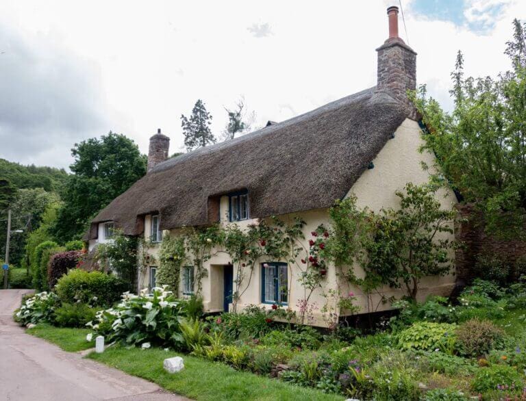 thatched roof cottage with a pretty country garden