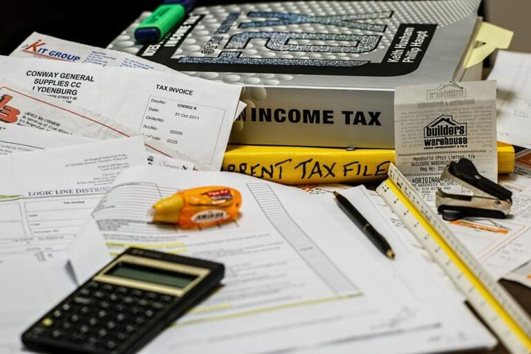 A calculator, bills and a tax return