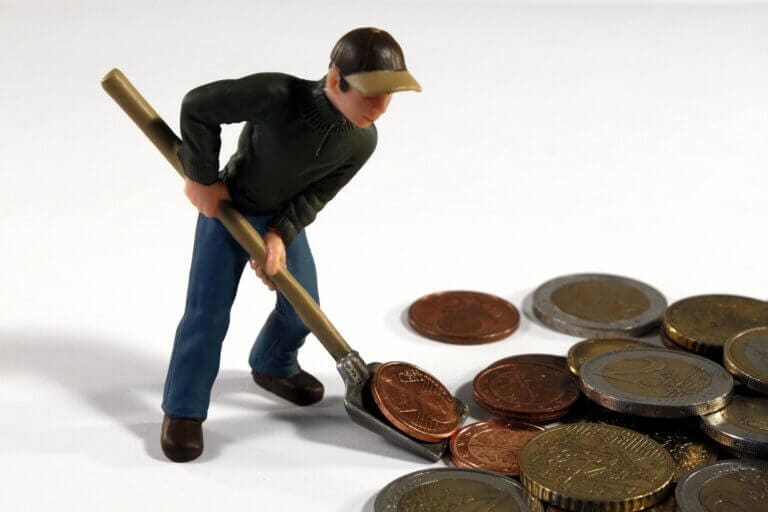 A toy man shovelling money