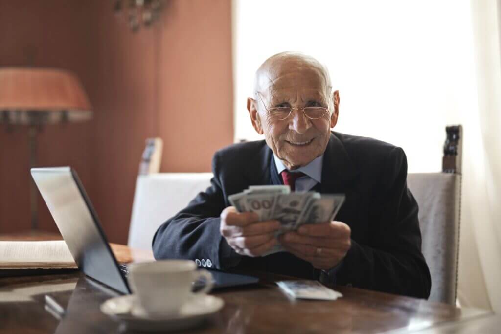 A happy retired man holding money