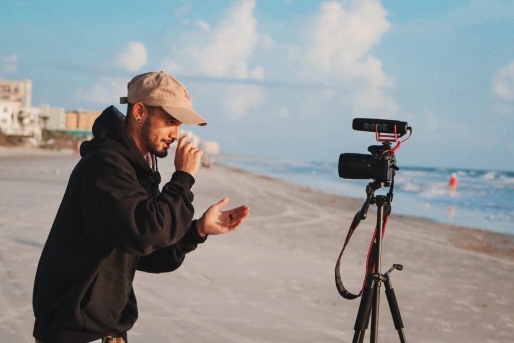 A vlogger creating a video on a beach