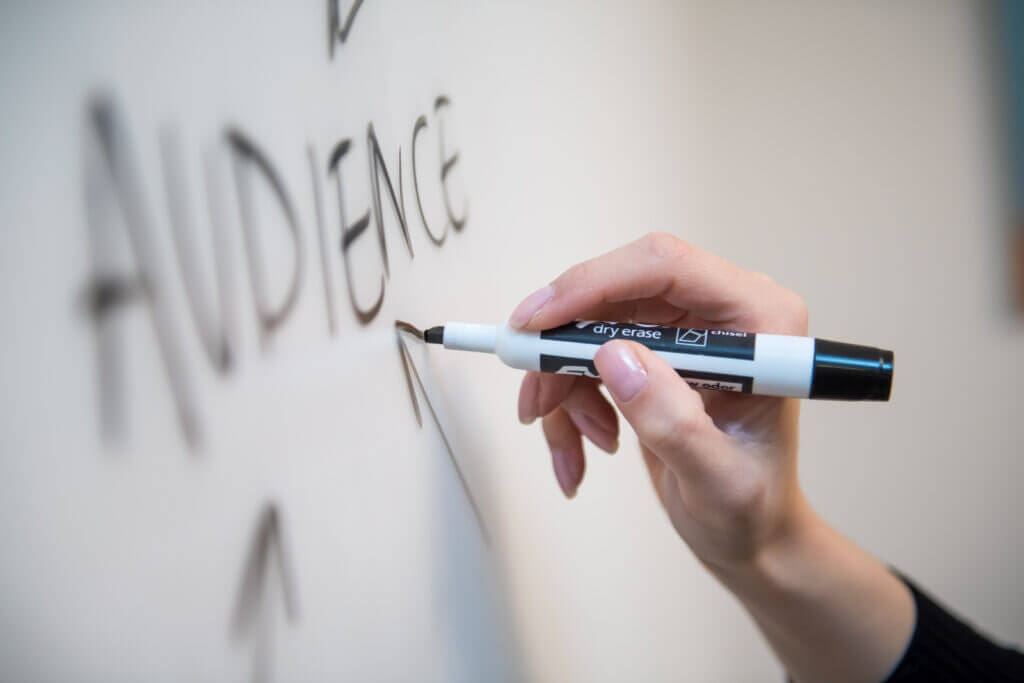 Writing the word "audience" on a white board