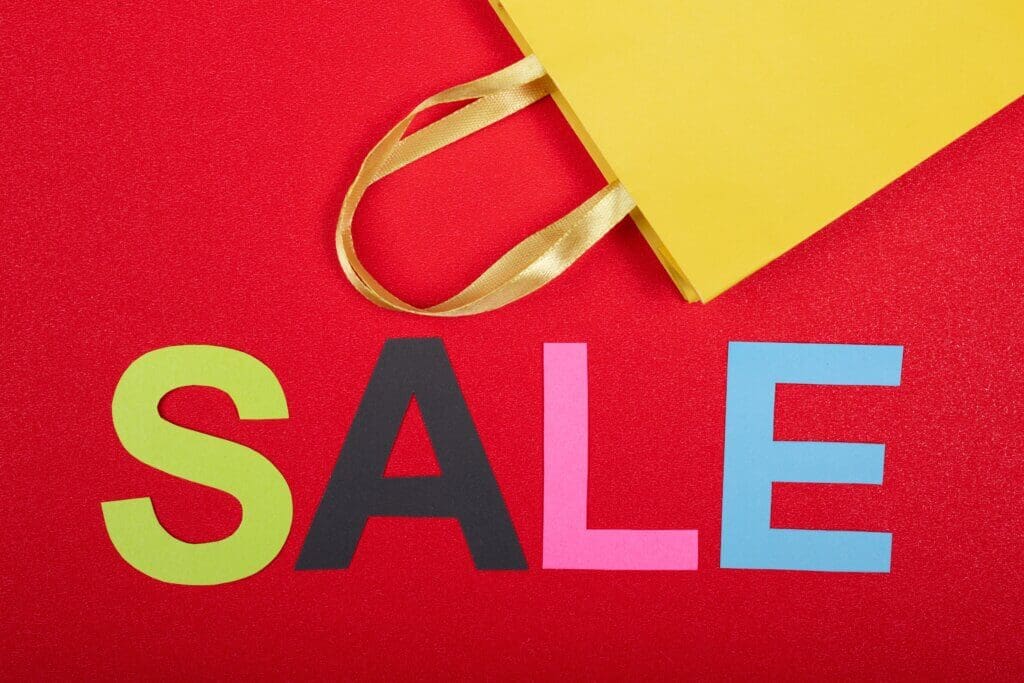 word sale letters on red card and yellow paper bag